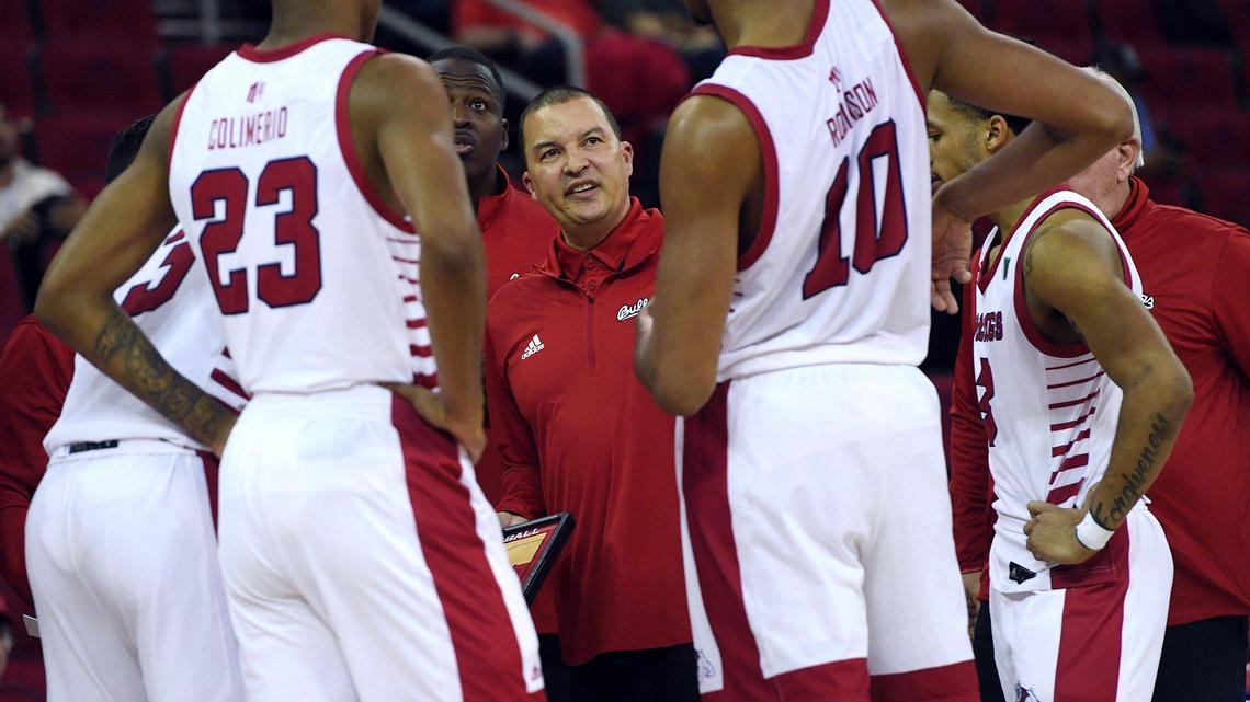 Fresno State coach Justin Hutson, center, looks toward Orlando Robinson, right, with Leo Colimerio to the left in a time out in the Bulldogs 61-54 victory over against Utah State Tuesday night, Jan. 18, 2022 in Fresno.