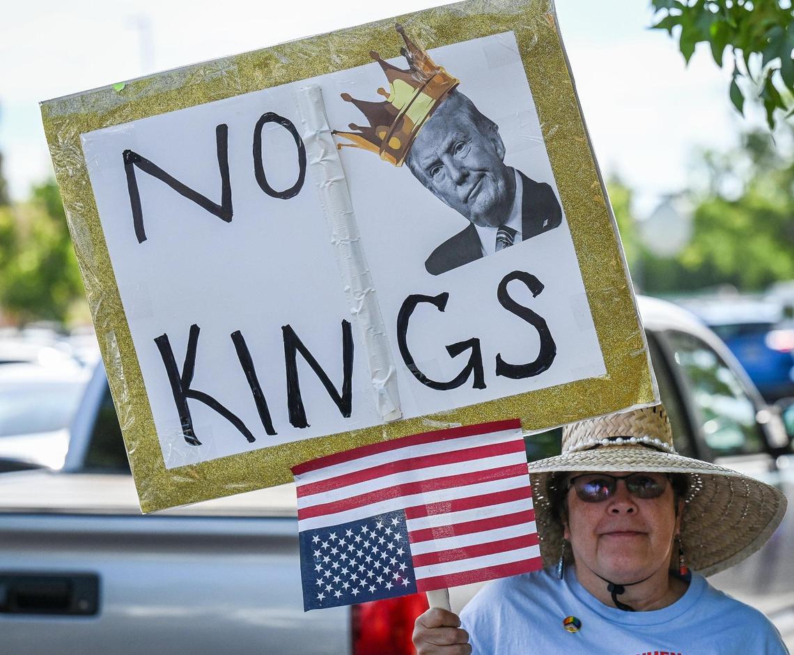 A protester holds an anti-Trump sign during a rally at Cary Park near Fashion Fair Mall in Fresno before marching toward Shaw Avenue for a “No Kings” protest against President Donald Trump’s policies on Saturday, June 14, 2025.