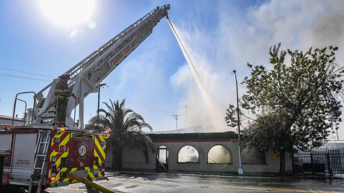 Fresno firefighters use a ladder truck to put water on a blaze burning Sunday, Oct. 10, 2021, at the La Tapatia factory warehouse on Belmont Avenue near Roeding Park in Fresno.