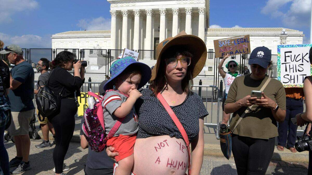 Una mujer embarazada lleva escrito en su vientre “Todavía no es un humanos” el 24 de junio, durante una manifestación contra el fallo que prohíben el aborto, frente al Tribunal Supremo en Washington (EEUU). Hacía semanas que se esperaba una decisión así y llegó finalmente este viernes. El alto tribunal tumbó la sentencia “Wade contra Roe”, emitida por el propio Supremo en 1973, que protegía el derecho constitucional al aborto en todo el país. El fallo del Supremo no prohíbe las interrupciones del embarazo, sino que deja en manos de cada uno de los 50 estados la potestad de legislar sobre ello, algo que llevan esperando desde hace tiempo muchos estados gobernados por republicanos.
