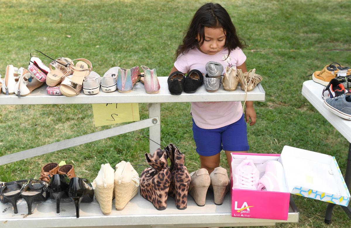 Savanah Lara, 4, checks out the shoes being given away at Cary Park in Fresno during the Community Kick it Outreach shoe giveaway on Saturday, Aug. 7, 2021. This is the fourth annual she giveaway organized by Pastor Edward Thomas of Living World International Church in Fresno to provide footwear for families in need before the start of the school year.