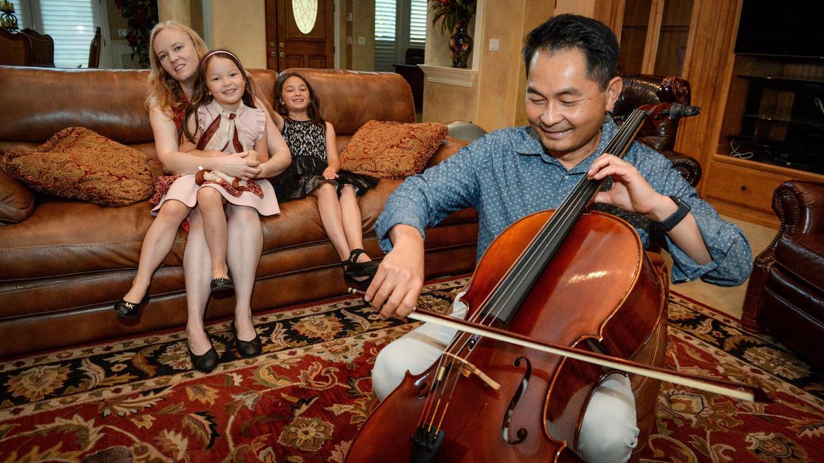 Mikhai Ta plays his cello for his wife Stephanie Fritz-Ta and daughters Annie Ta, 7, left, and Ellie Ta, 9, at their new home in Clovis on Tuesday, June 19, 2019. The cello was one of the few items taken when the family evacuated from their home in Paradise, CA before it burned in last year’s wildfire. After months of living in temporary housing the family settled in Clovis where they were able to buy the former owners’ furnishings.