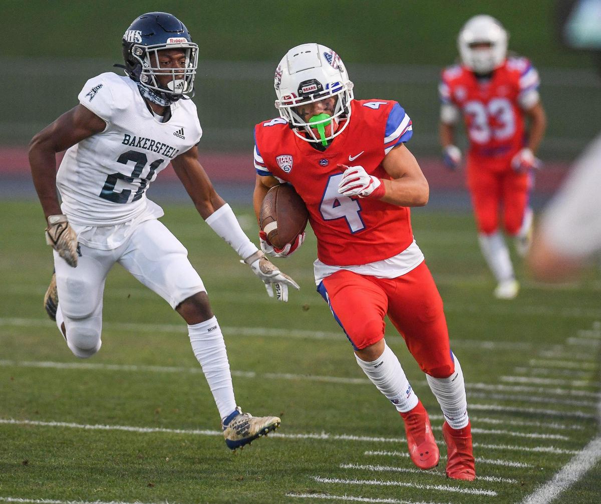 Buchanan’s Hilton Green runs along the sideline with Bakersfield’s Malakhi Anderson in pursuit during their game at Veterans Memorial Stadium on Friday, Aug. 19, 2022.