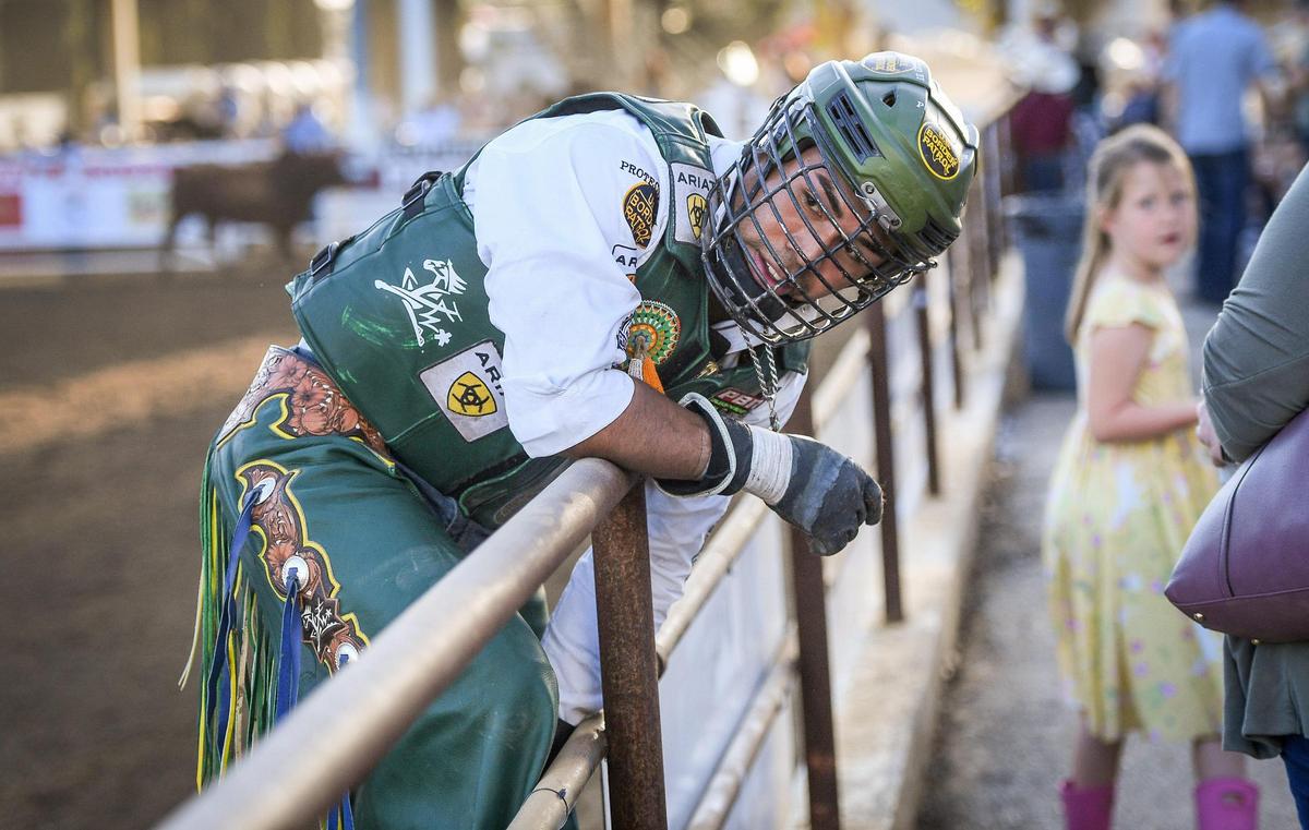 Keyshawn Whitehorse jumps onto the rail after his ride on Red Hawk in the first section of bull riding during the Professional Bull Riders event on the opening day of the Clovis Rodeo on Wednesday, April 20, 2022.