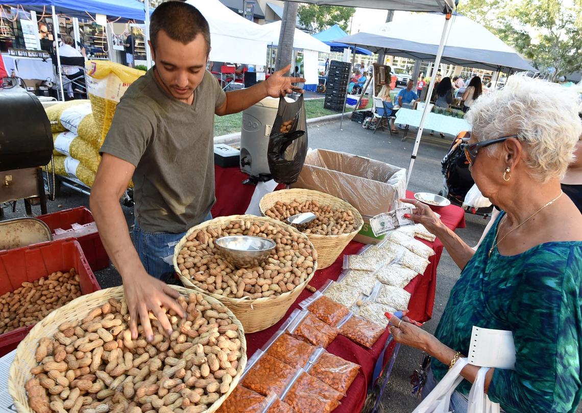 Gina Marquez buys a variety of roasted peanuts from vendor Efrain Gonzalez at River Park Farmers Market in this Fresno Bee file photo from 2018.