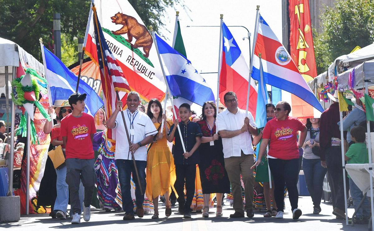 Marchers bear the flags of California as well as Mexico and other Latin American countries as the Fiestas Patrias parade, celebrating Mexican Independence Day and more, returns to downtown Fresno’s Fulton Street on Saturday, Sept. 17, 2022.