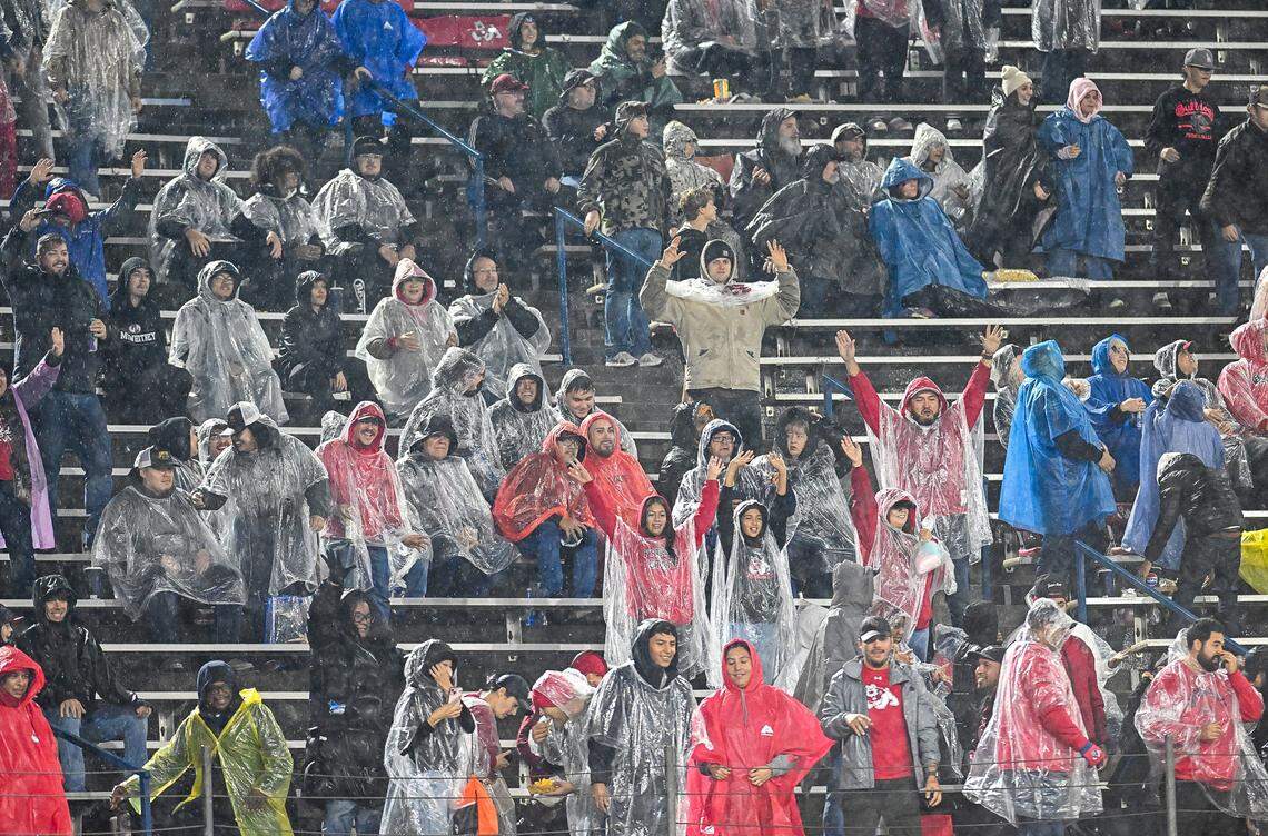 Fresno State fans cheer while watching the Bulldogs game against Wyoming in heavy rain at Valley Children’s Stadium on Saturday, Nov. 16, 2025. 