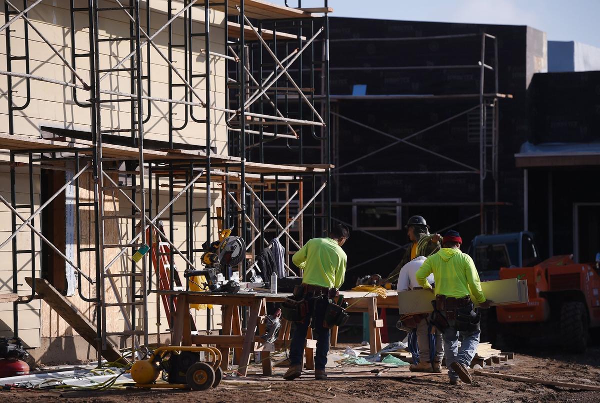 Workers begin to gather tools at affordable apartments being constructed along Kings Canyon Avenue east of Willow Avenue. Photographed Thursday, Jan. 31, 2019 in Fresno.