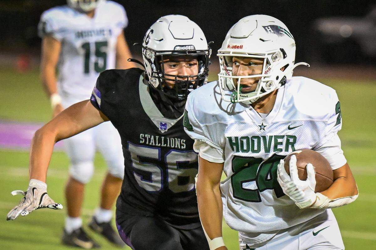 Hoover's Paul Escoto, right, tries to turn the corner on a run while being pursued by Madera South's Antonio Fonseca during their game at Madera South Stadium on Friday, Sept. 19, 2025.