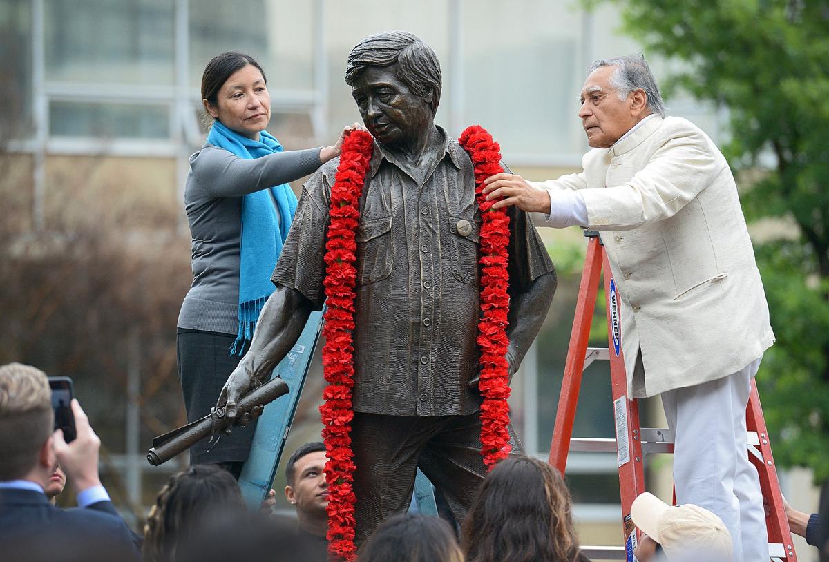 Julie Chávez Rodríguez, granddaughter of civil rights leader César E. Chávez, and Fresno State emeritus faculty member Dr. Sudarshan Kapoor, place a garland around the statue of Chávez in the Peace Garden at Fresno State in 2018. Chávez Rodríguez is the campaign manager for President Joe Biden’s re-election campaign. 