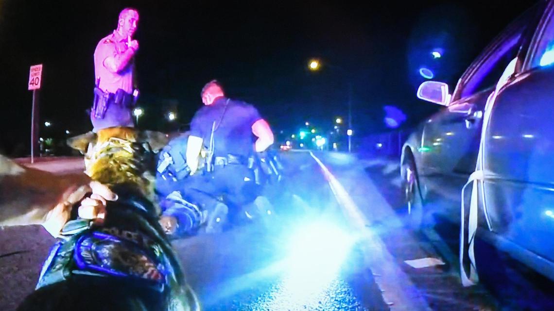A screen shot from Clovis police body cam footage shows officers holding Jamal Jones of Fresno on the ground while a police canine is held back after biting Jones during a traffic stop in Clovis last year. Clovis Police Chief Curt Fleming said the excessive force allegations were untrue during a press conference at the Clovis Police Department on Thursday, April 28, 2022.