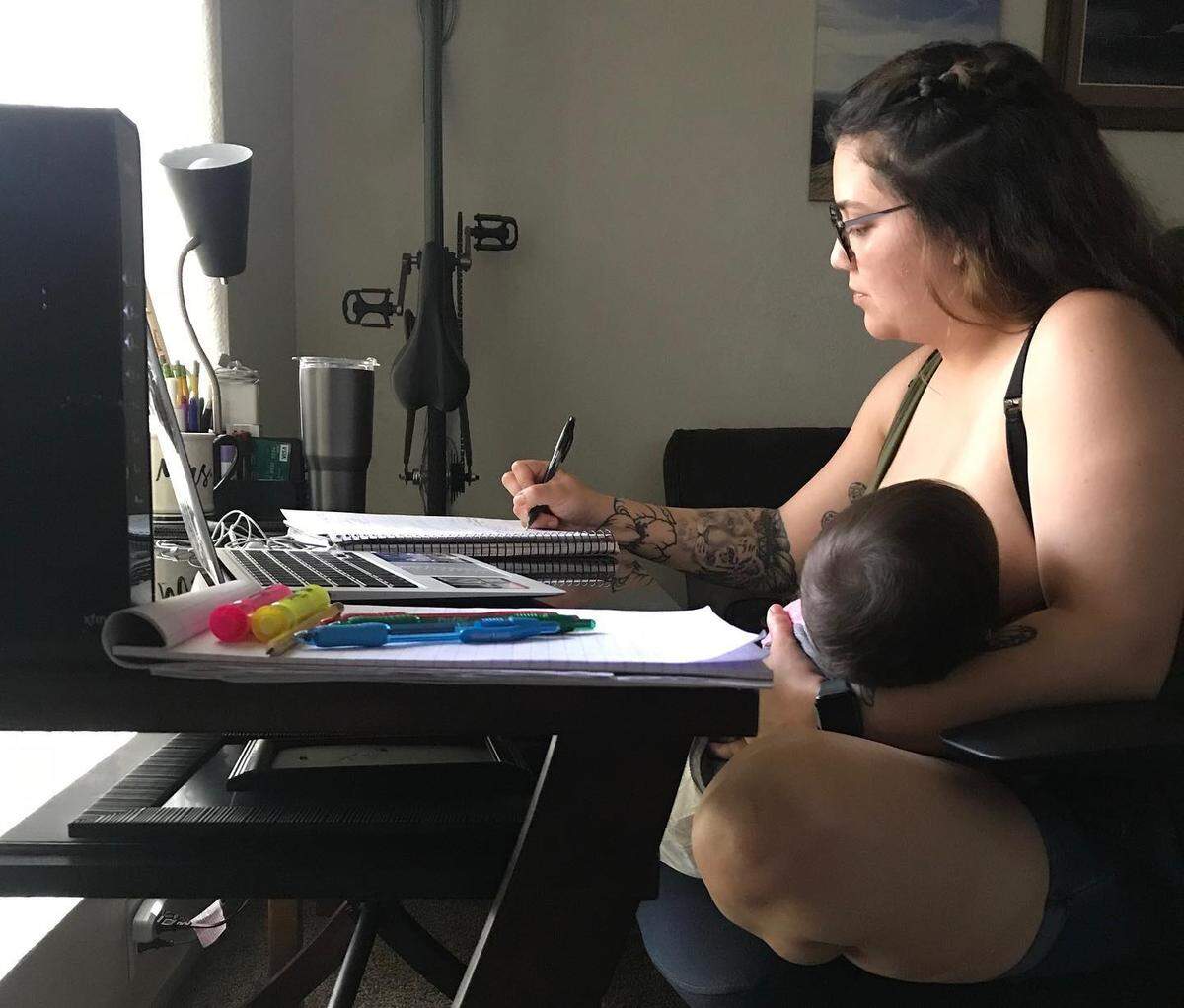 Fresno City College student Marcella Mares breastfeeds her 10-month-old daughter while studying at home during the COVID-19 pandemic.
