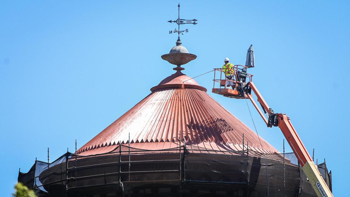 A worker paints the roof of the Fresno Water Tower on Tuesday, May 24, 2022. The historic water tower on Fresno and O Streets in downtown Fresno is going through a $1.2 million renovation project. When completed the visitors’ center will reopen along with the Frida Cafe coffee shop.