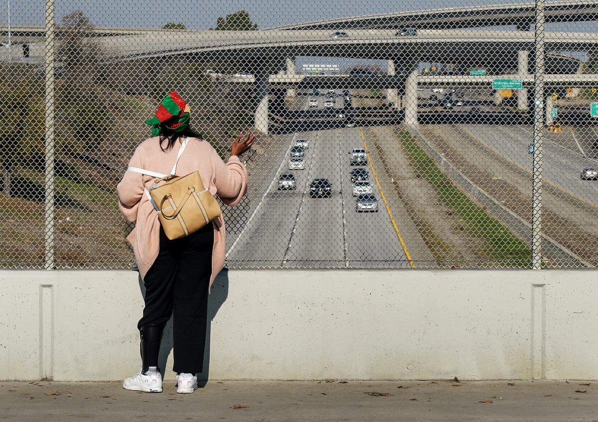 Cheryl “Monique” Turks, 47, of Fresno, waves from a freeway overpass as she has been doing nearly everyday for about 15 or more years. She has waved from the various overpasses along Highway 41 from Barstow Avenue to Dakota and others but now finds the Belmont Avenue a good one because she sees drivers from all the area freeways.