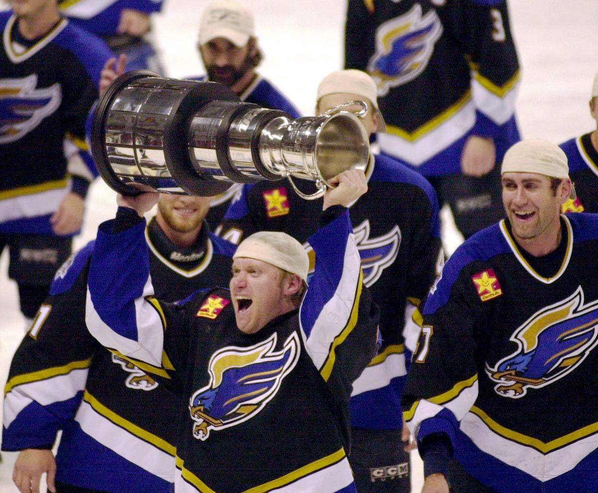 Fresno left wing Mike Mathers celebrates with the Taylor Cup after the Falcons defeated Idaho 3-2 in double overtime for the WCHL championship Friday night at the Bank of America Centre in Boise.