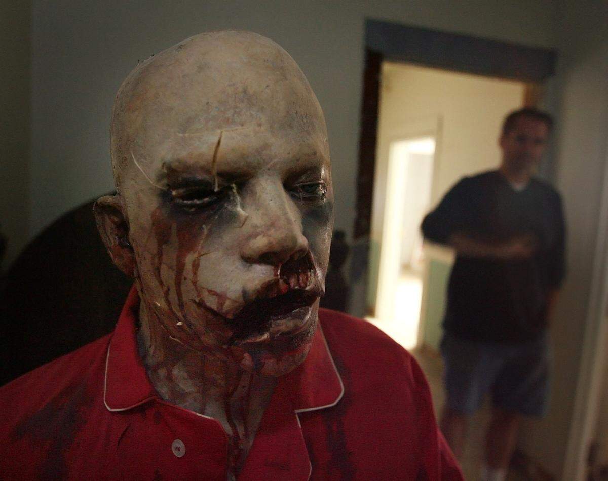 Owner Todd Wolfe stops to look at one of the animatronic dummies used in his Scream If You Can haunted house in Clovis on Monday, Oct. 22, 2007.