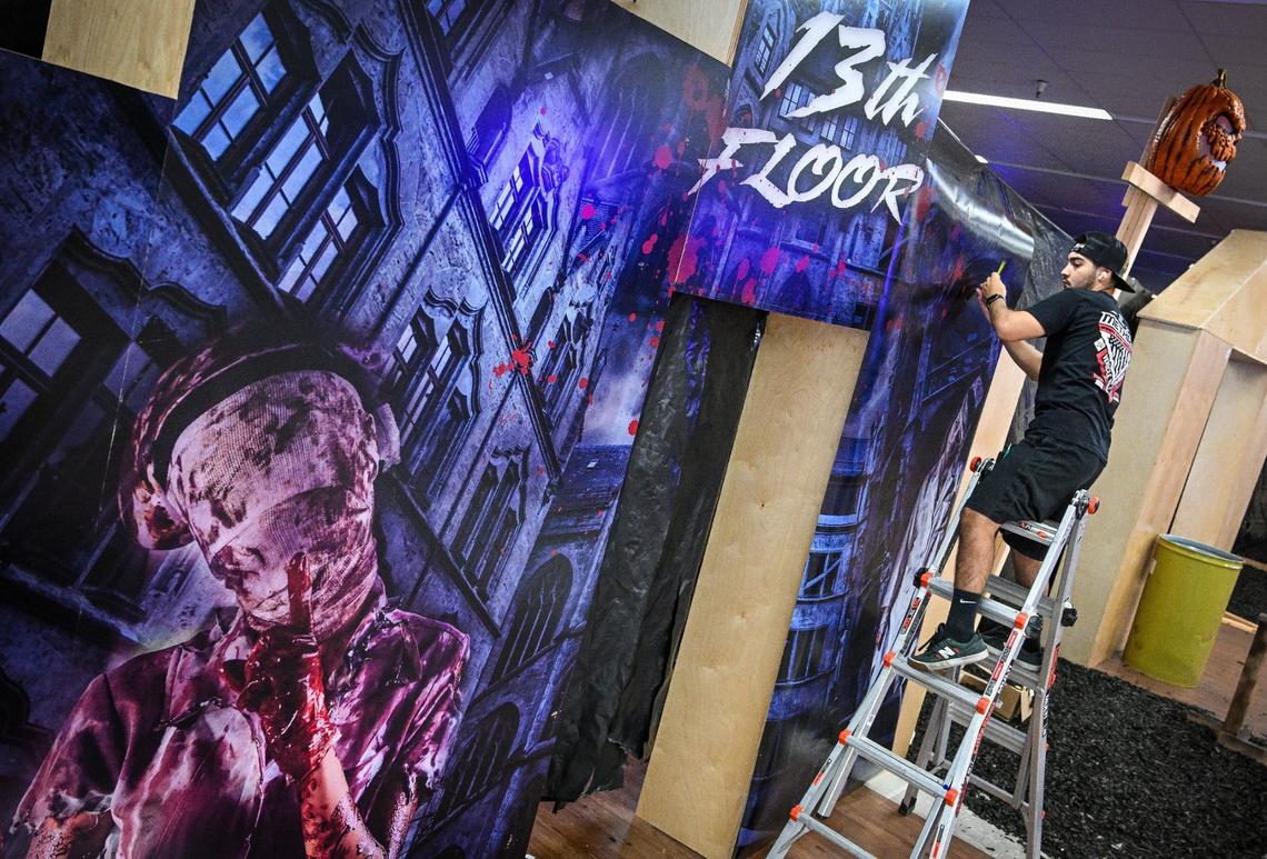 Benny Salazar helps put up image coverings for the 13th Floor, one of three different maze haunts at Scare Factory in Fresno.