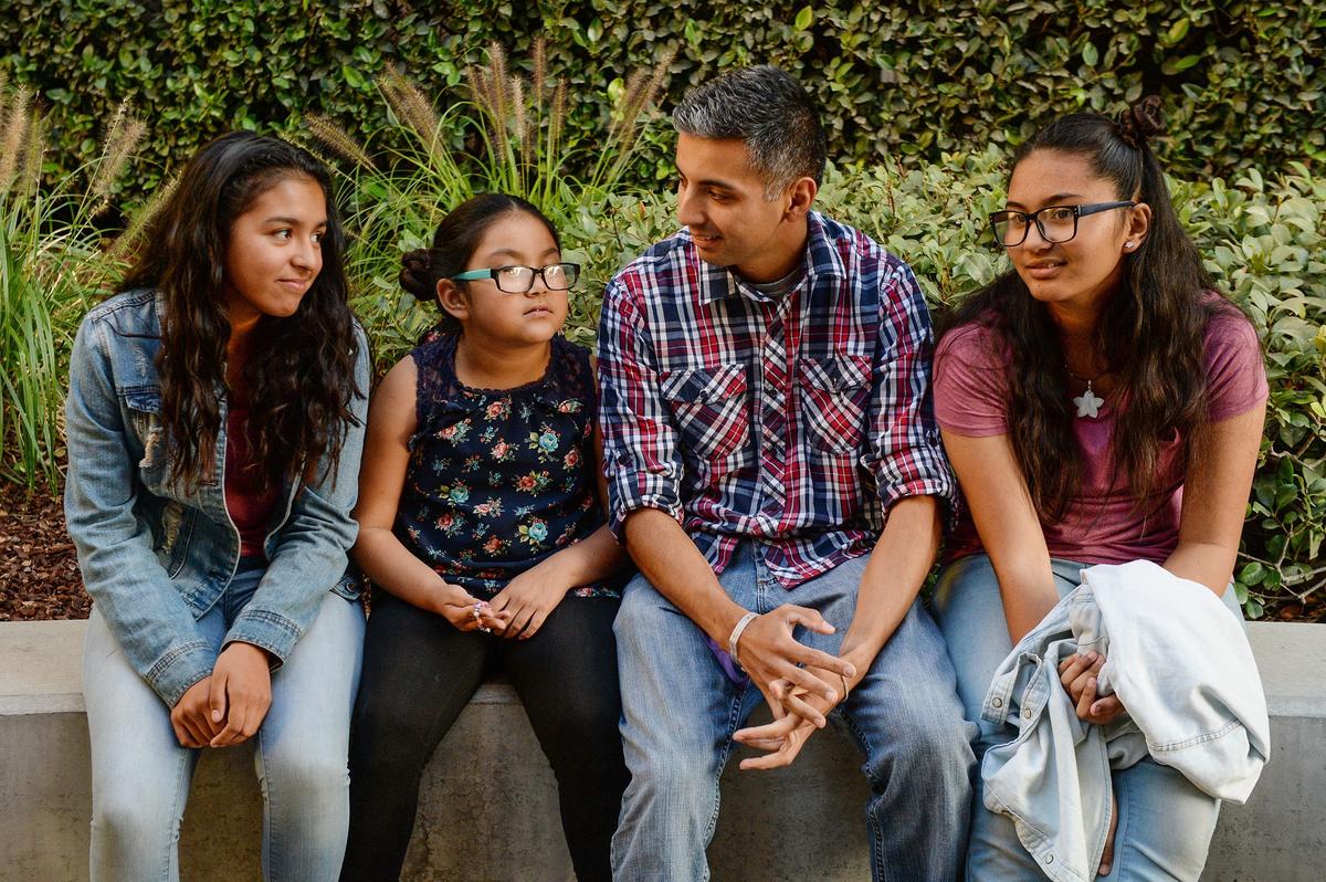 Elesandro Flores Jr. sits with his daughters, from left, Kiara Flores, Adriene Flores, and Lanyssa Vasquez outside Community Regional Medical Center in Fresno after visiting his newborn daughter Quinn on Tuesday, Oct. 30, 2018.
