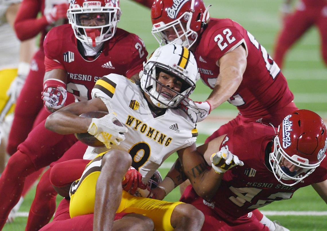 Fresno State’s defense piles onto Wyoming wide receiver Joshua Cobbs, center, in game action Friday, Nov. 25, 2022 in Fresno. The Bulldogs led 23-0 at halftime.