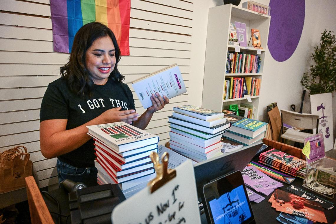 Ashley Mireles-Guerrero checks out newly arrived books at her independent bookstore, Judging by the Cover, which recently opened in Fresno’s Chinatown.