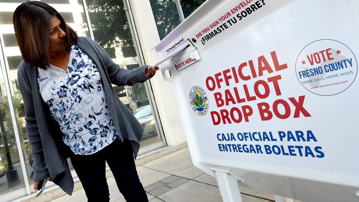 Voter Eva Frias casts her ballot at the drop box at the Fresno County Elections Office in downtown Fresno, March 3, 2020.