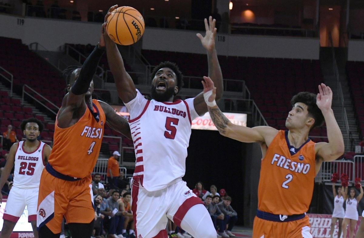 Fresno State guard Jordan Campbell drives between Fresno Pacific’s Michael Mensah, left, and Isaac Peralta, right, Monday, Nov. 7, 2022 in Fresno. The Bulldogs beat the Sunbirds 69-56.