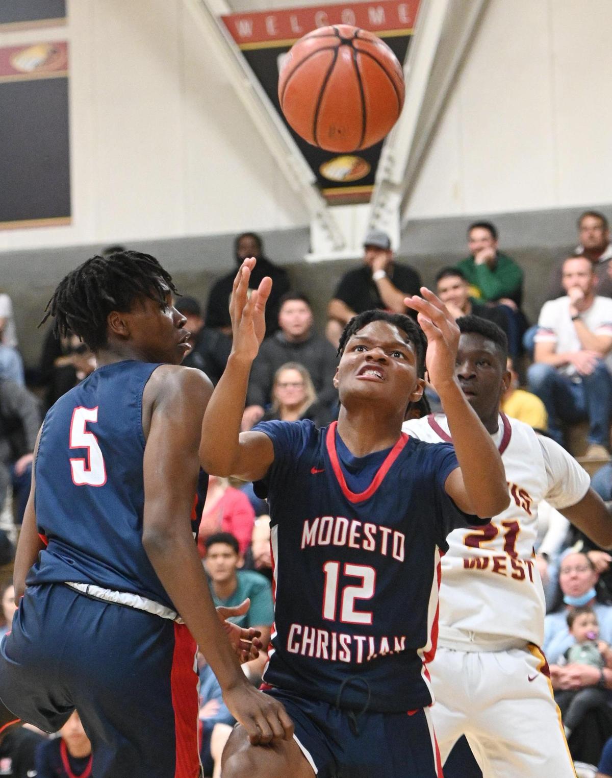 Modesto Christian’s Zeke Davis, center, goes to grab a rebound against Clovis West during their NorCal Open Division boys basketball semifinal at Clovis West on Saturday, March 5, 2022.