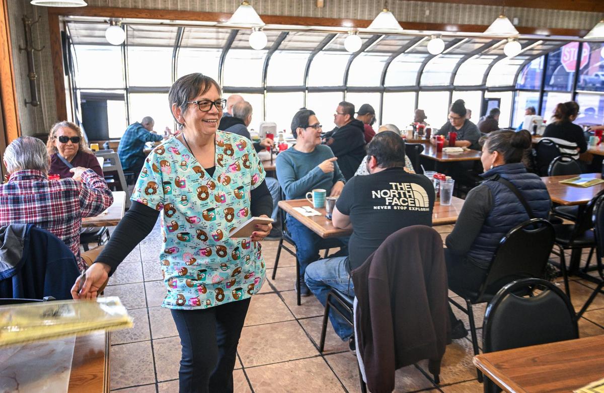 Sandy Richardson, manager at Al’s Cafe, greets some of her loyal customers at the restaurant on Friday, Feb. 21, 2205. The cafe was recently forced to raise prices to make up for the higher cost of eggs but Sandy says they are still much lower than at similar restaurants.