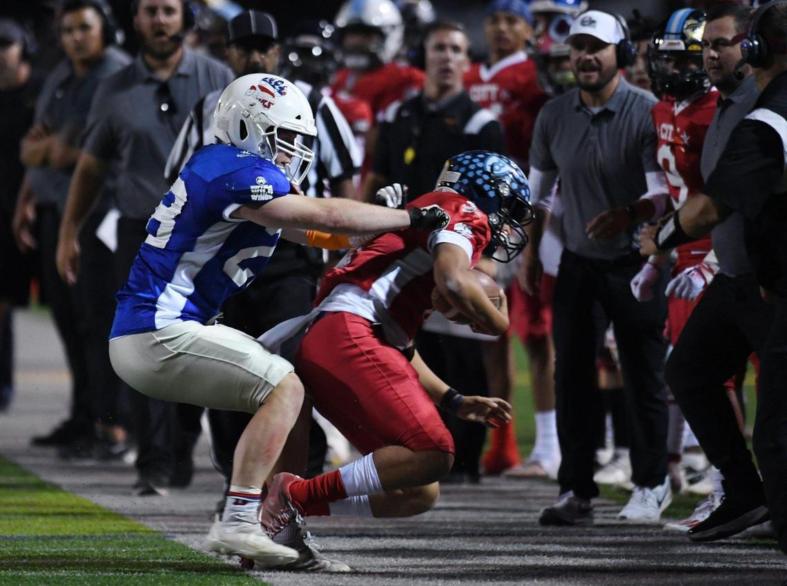 Buchanan’s Caden Rogers, left playing for County, shoves City’s quarterback Roland Russo out of bounds at the City/County All-Star football game held at McLane High’s stadium Friday night, June 17, 2022 in Fresno. The game ended 21-21.