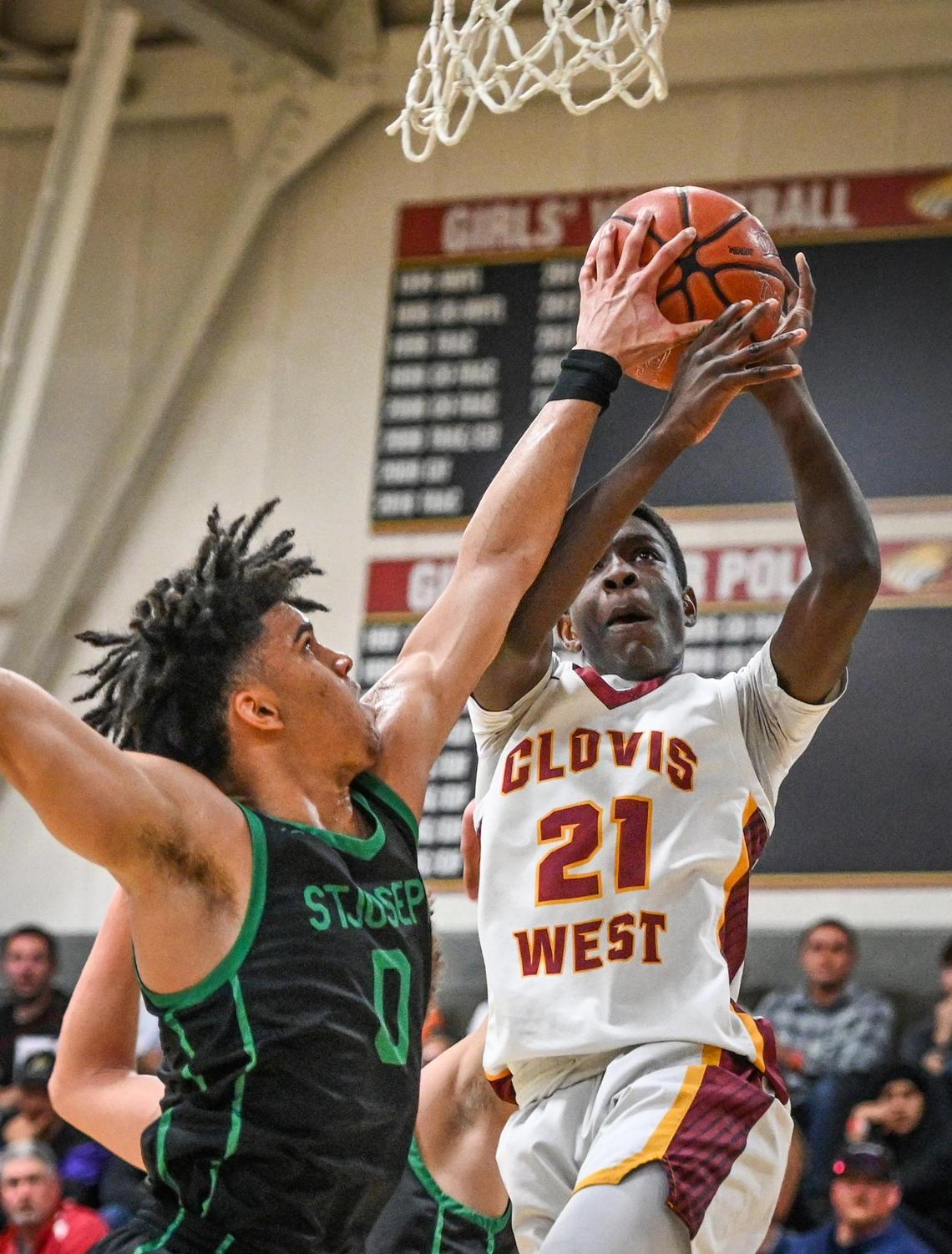 Clovis West’s Dj Stickman, right, goes to the hoop but has his shot blocked by St. Joseph’s Dre Roman during their Central Section Open Division championship game at Clovis West on Saturday, Feb. 26, 2022.