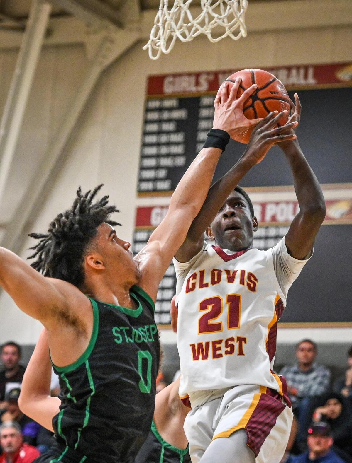 Clovis West’s Dj Stickman, right, goes to the hoop but has his shot blocked by St. Joseph’s Dre Roman during their Central Section Open Division championship game at Clovis West on Saturday, Feb. 26, 2022.