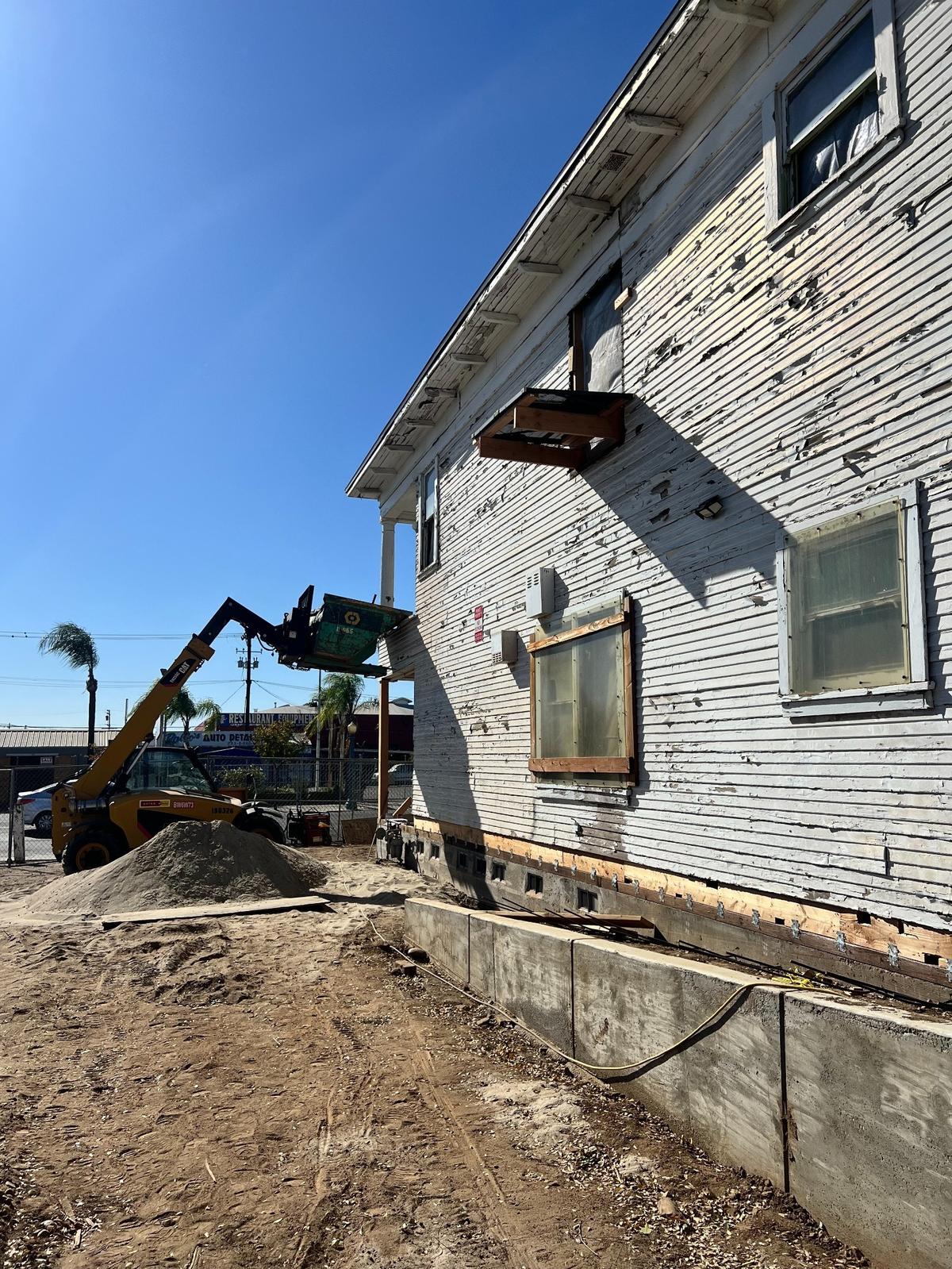 Crews work to clear debris from a 100-plus-year-old Elia Home on Van Ness Avenue in downtown Fresno, California.