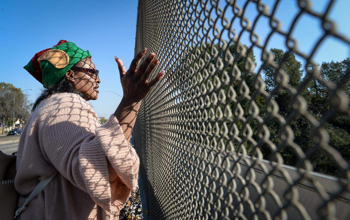 Cheryl “Monique” Turks, 47, of Fresno, waves from the Belmont Avenue overpass at Highway 41 in Fresno on Wednesday, Jan. 2, 2019.