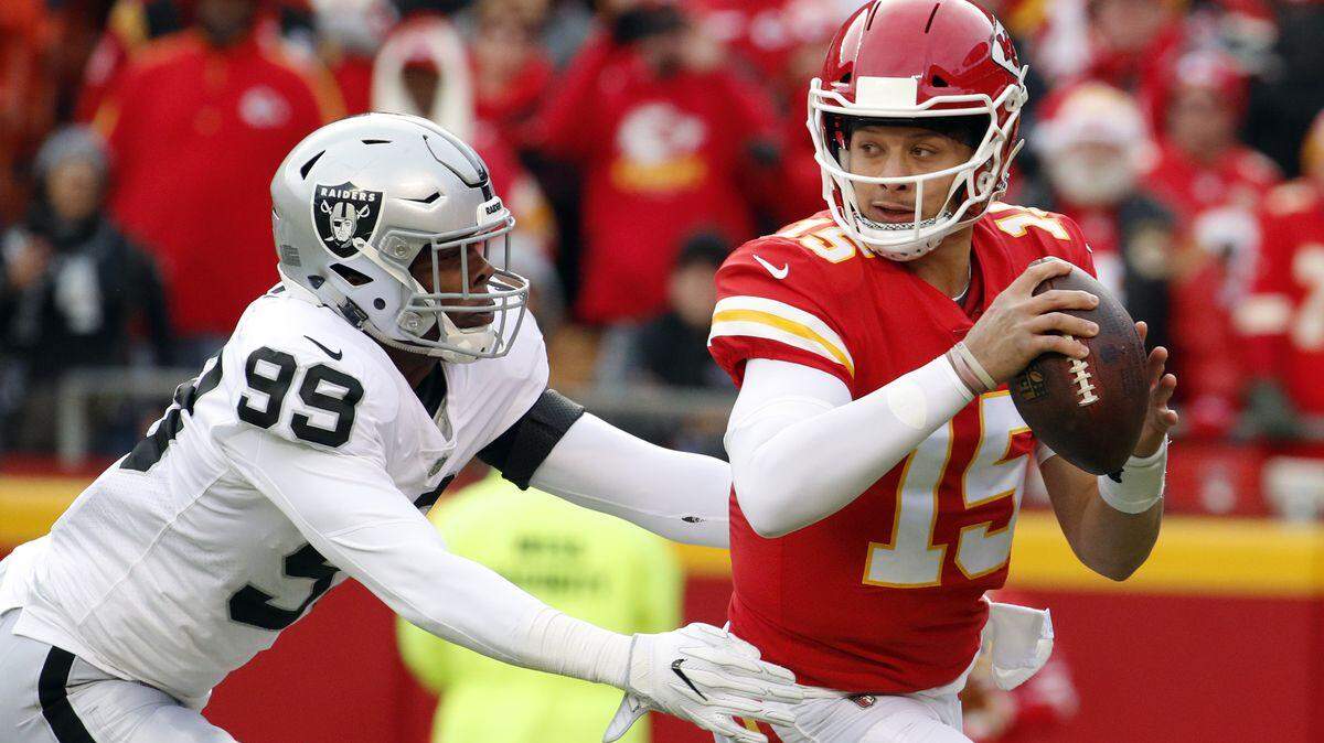 FILE - In this Sunday, Dec. 30, 2018 file photo, Kansas City Chiefs quarterback Patrick Mahomes (15) breaks a tackle-attempt by Las Vegas Raiders defensive end Arden Key (99) during the first half of an NFL football game in Kansas City, Mo.