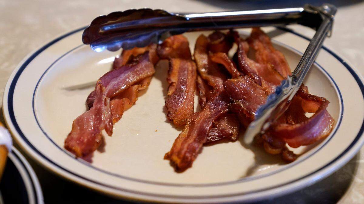 A plate of bacon on the kitchen table of the Ron Mardesen farm near Elliott, Iowa. A 2018 voter-approved California ballot measure, which became effective Jan. 1, set the nation’s toughest living-space standards for breeding pigs. Critics have called for putting off enforcement until 2024 for fear prices will rise and jobs will be lost. Mardesen already meets the California standards for the hogs he sells to specialty meat company Niman Ranch, which supported passage of Proposition 12 and requires all of its roughly 650 hog farmers to give breeding pigs far more room than mandated by the law.