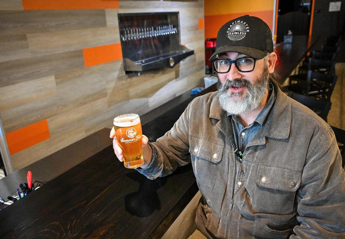 Jason Hatwig, a co-owner of Summer Fox, holds up a beer at the bar at the local brewery’s new location at the old Club Fred and Audie’s Olympic in the Van Ness Village area of the Tower District on Monday, March 25, 2025.