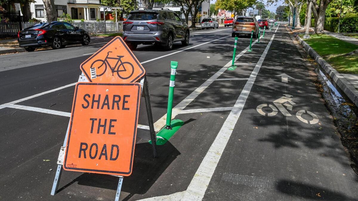 A cycling road sign stands next to a new bike lane located on Van Ness Avenue near Olive Avenue on Tuesday, Sept. 20, 2022. Although a few markings and signs denote the changes, motorists have been parking in the bike lanes mostly due to confusion about the new layout meant to protect cyclists.