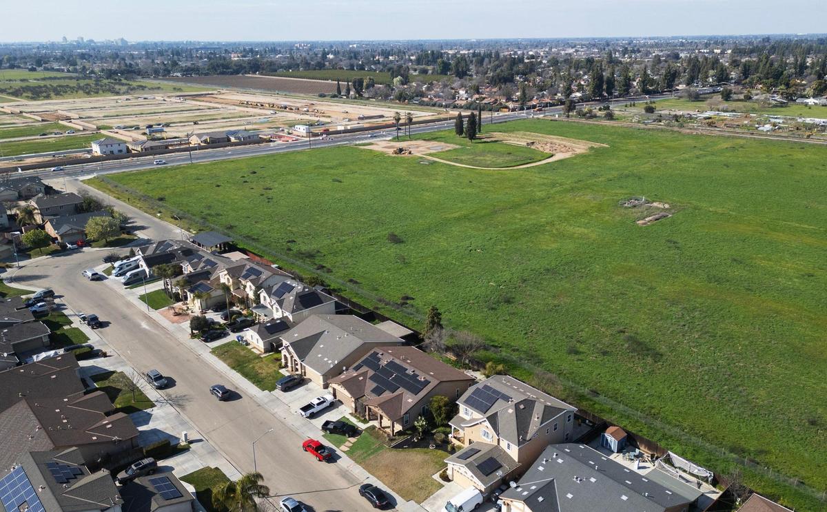 Situated behind a row of houses, an aerial view shows a new 49-acre park being developed along South Peach Avenue, top left. Photographed Wednesday, Feb. 19, 2025, in Fresno.