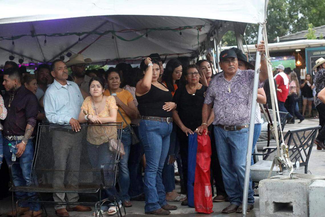 La gente se cubre durante las inclemencias del tiempo durante parte de MicheFest.