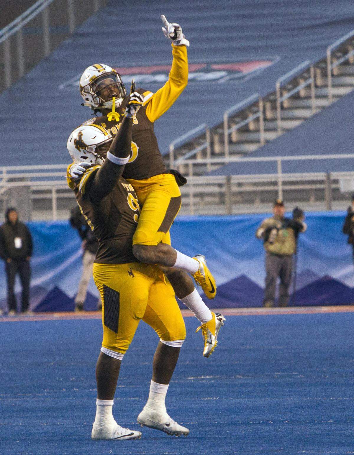 Wyoming defensive tackle Youhanna Ghaifan picks up cornerback Rico Gafford after the defense forced a Central Michigan fumble and ensuing touchdown in the 2017 Famous Idaho Potato Bowl.