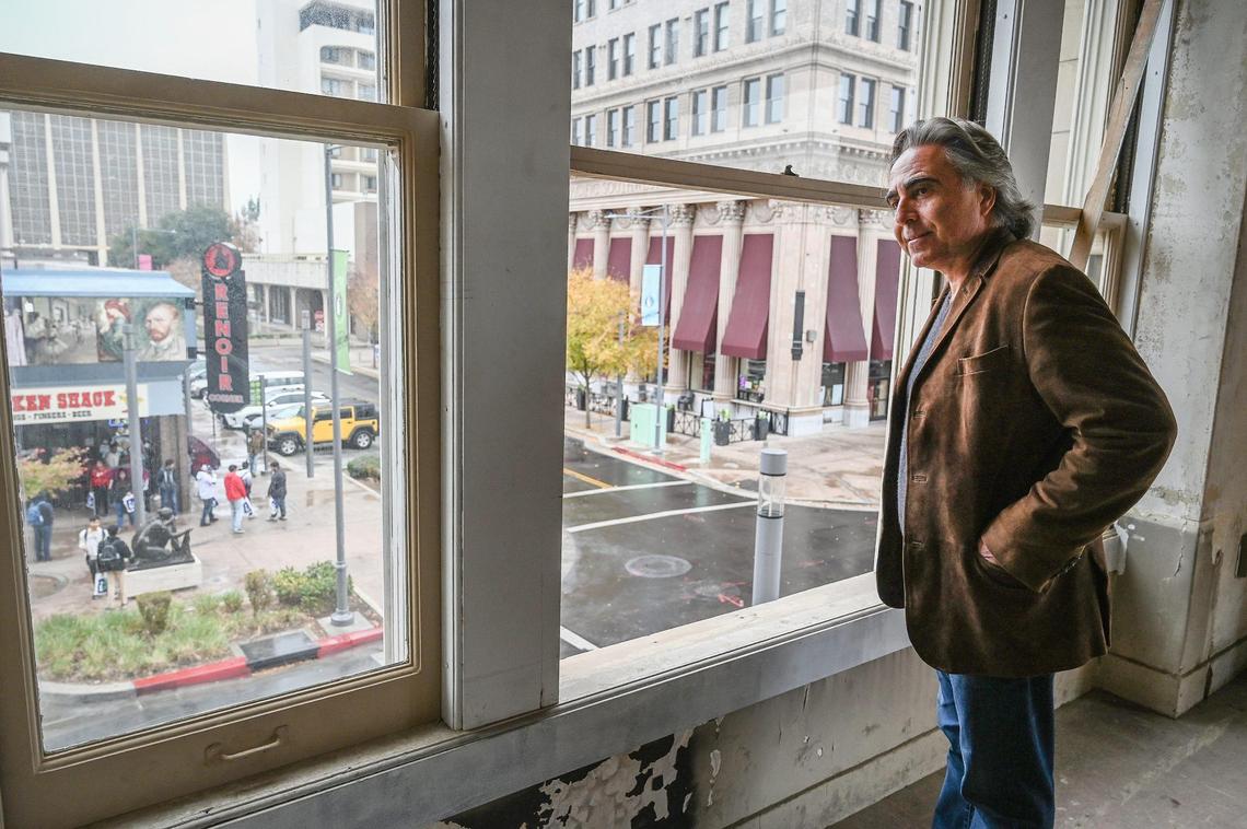 Sevak Khatchadourian looks from the second floor loft of the Helm Building toward Renoir Corner and his own Pacific Southwest Building in downtown Fresno on Thursday, Dec. 1, 2022. Khatchadourian is hoping to develop the Helm Building with new micro apartments in addition to retail spaces on the ground floor.