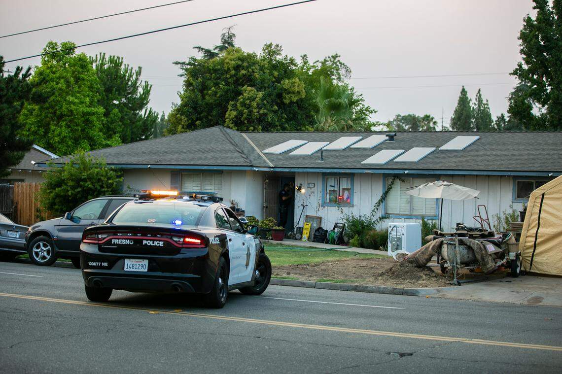 Police block off the street in front of a home as they seek suspects in a robbery and shooting at the River Park shopping center Friday Aug. 6, 2021, in Fresno, California.