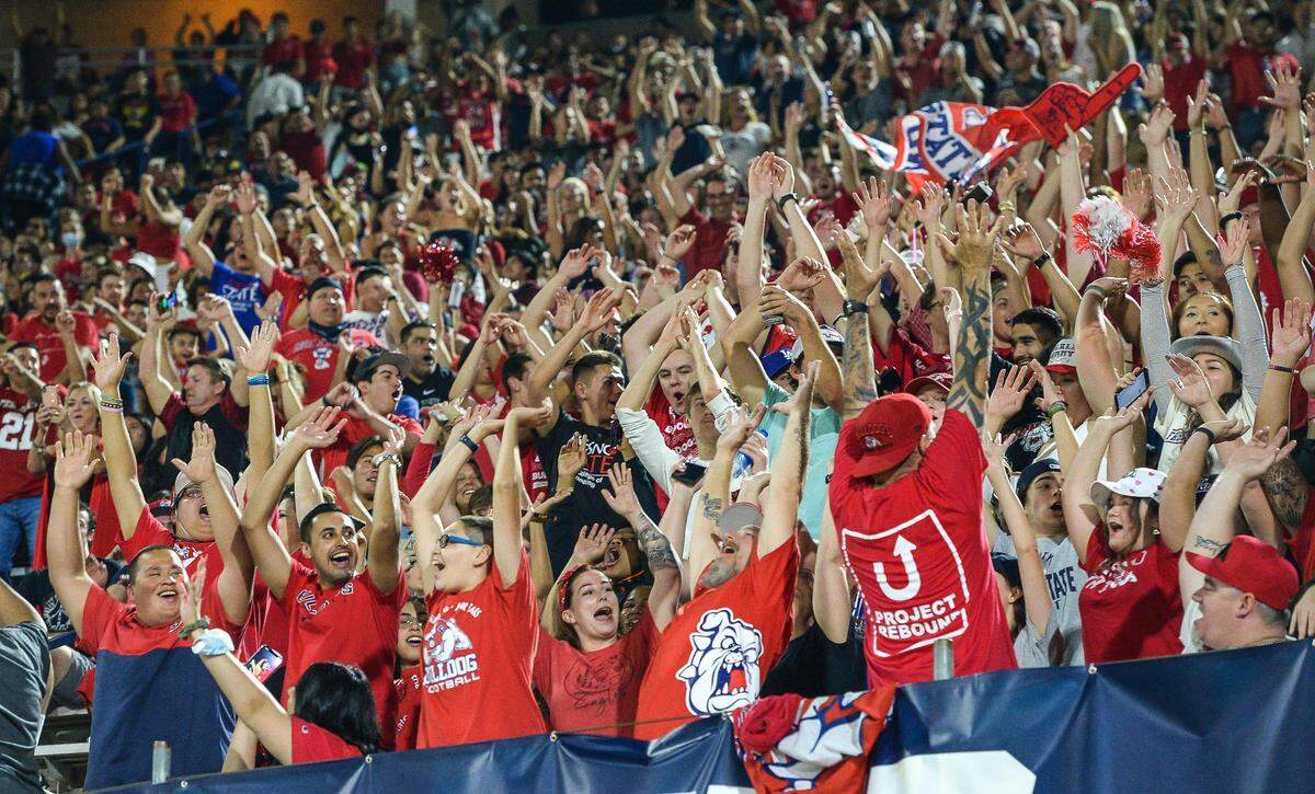 Fans in the Fresno State student section do the wave cheer during the Bulldogs’ game against UNLV at Bulldog Stadium on Friday, Sept. 24, 2021.