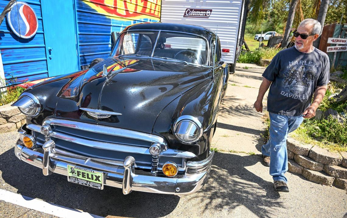 Mark Bagdasarian, who owns the Yosemite Hemp Co. in Friant walks by one of his classic cars that sit outside the CBD shop on Wednesday, April 4, 2025.