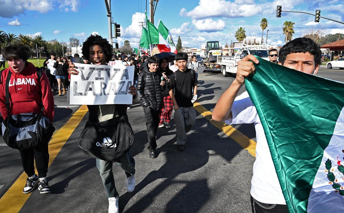 Students from McLane High School cross Dakota Avenue as they march along Cedar Avenue protesting anti-immigration sentiment in the Federal government Friday, Feb. 7, 2025 in Fresno.