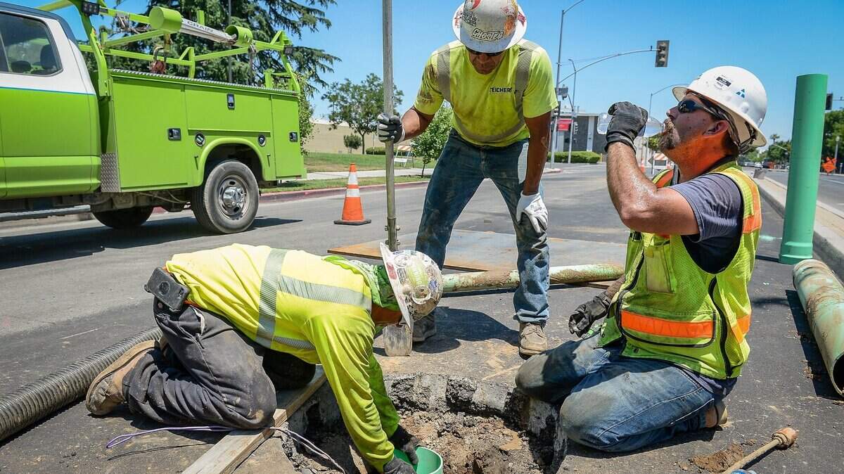 Casey Holeman, from left, Vincente Alaniz and Tris Pennington of Teichert Construction work in 100-degree heat installing water lines for the City of Fresno’s recycled water project on Fresno Street in downtown Fresno on Wednesday, May 27, 2020. At least another day of high temperatures is expected on Thursday. 