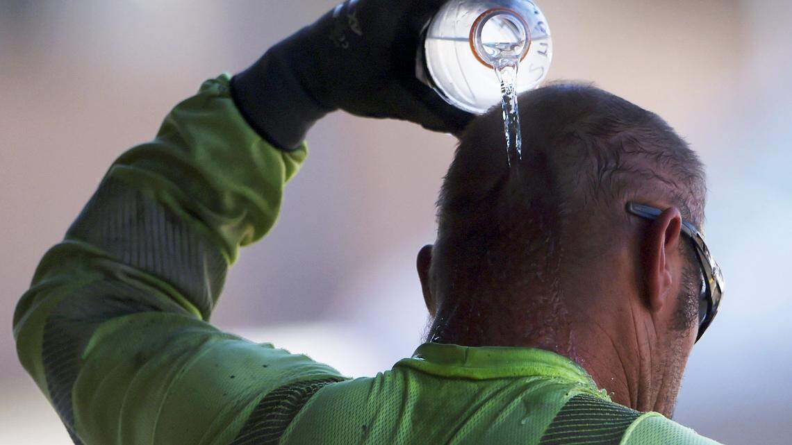 A construction worker pours a bottle of water over his head as he cools off in the shade at the end of the work day Wednesday, June 21, 2017 in Fresno.
ERIC PAUL ZAMORA/THE FRESNO BEE