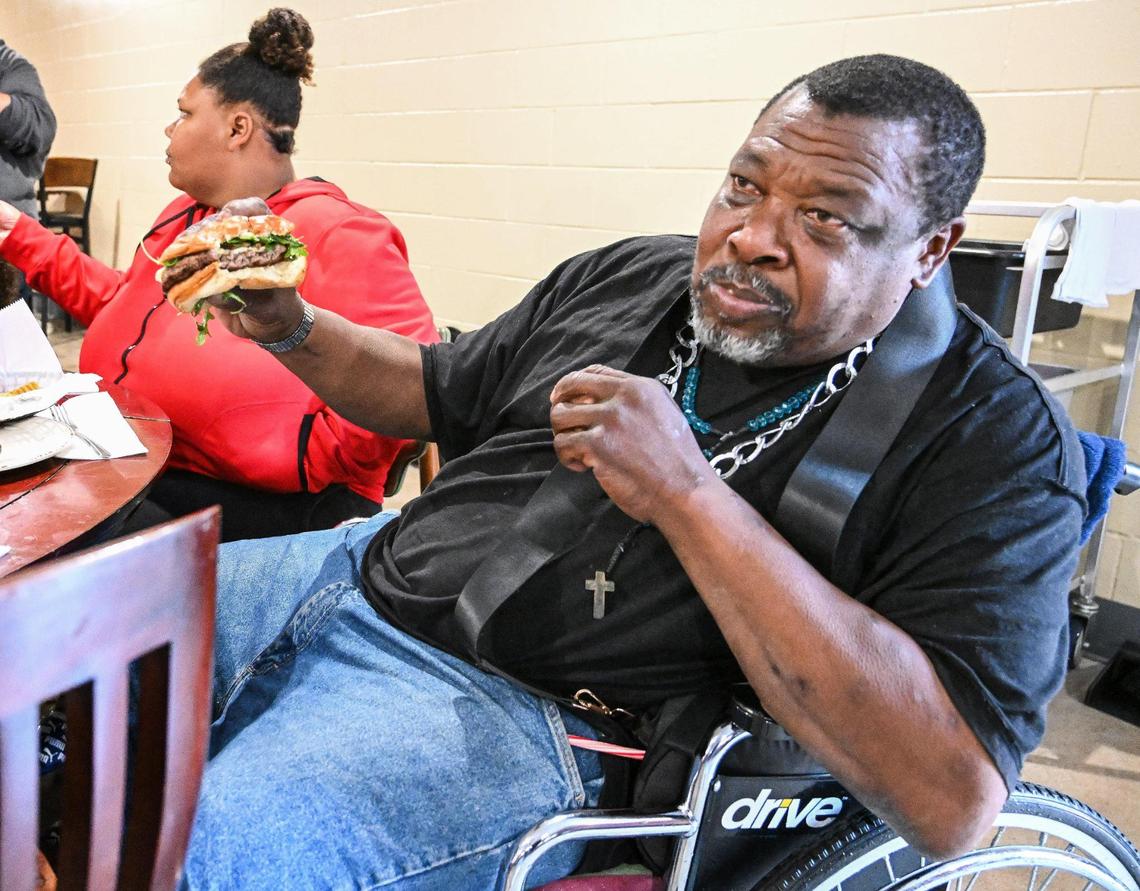 Jessie Williams of Fresno savors his cheeseburger at the new Papa Mike’s Café, a restaurant-style cafe serving no-cost meals to anyone who wants one, during its grand opening at the Poverello House on Wednesday, Jan. 24, 2024.