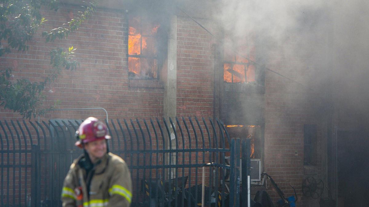 Fire is visible through the windows at the back part of a La Tapatia factory warehouse on Belmont Avenue near Roeding Park in Fresno on Sunday, Oct. 10, 2021.