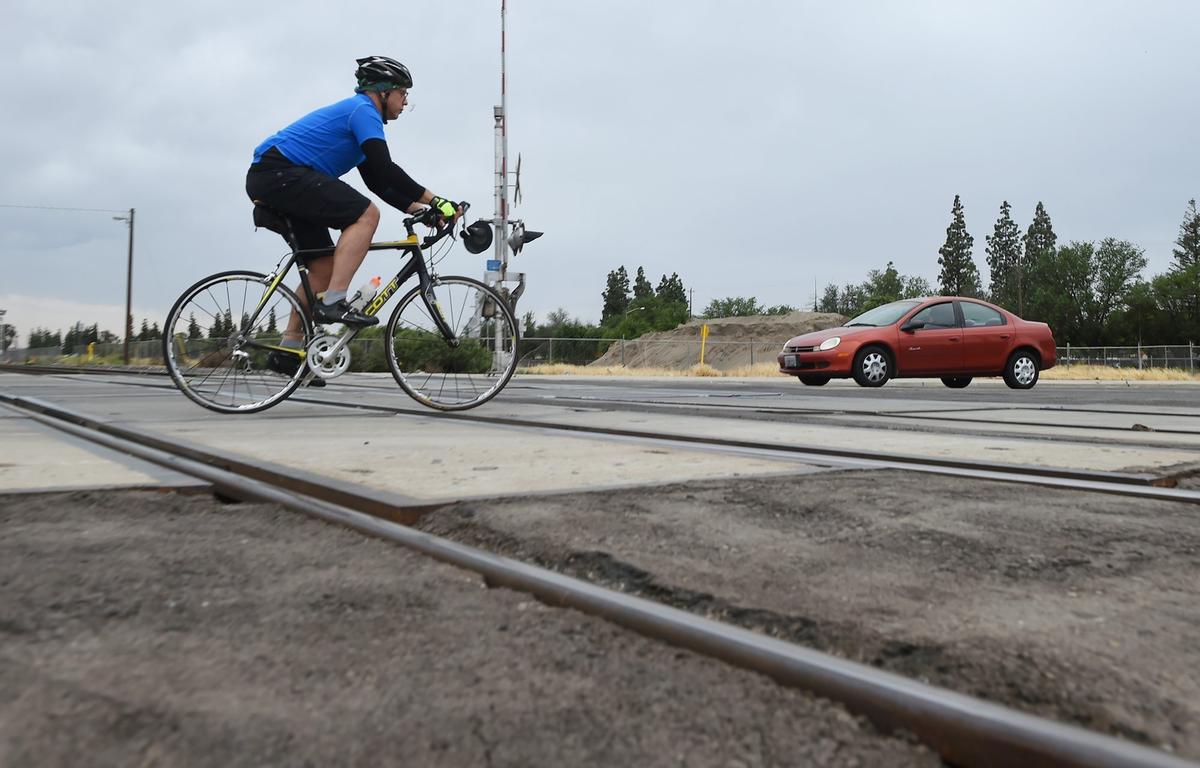 The Fresno Bee’s Marek Warszawski crosses railroad tracks as he nears the office Wednesday, May 15, 2019 in Fresno